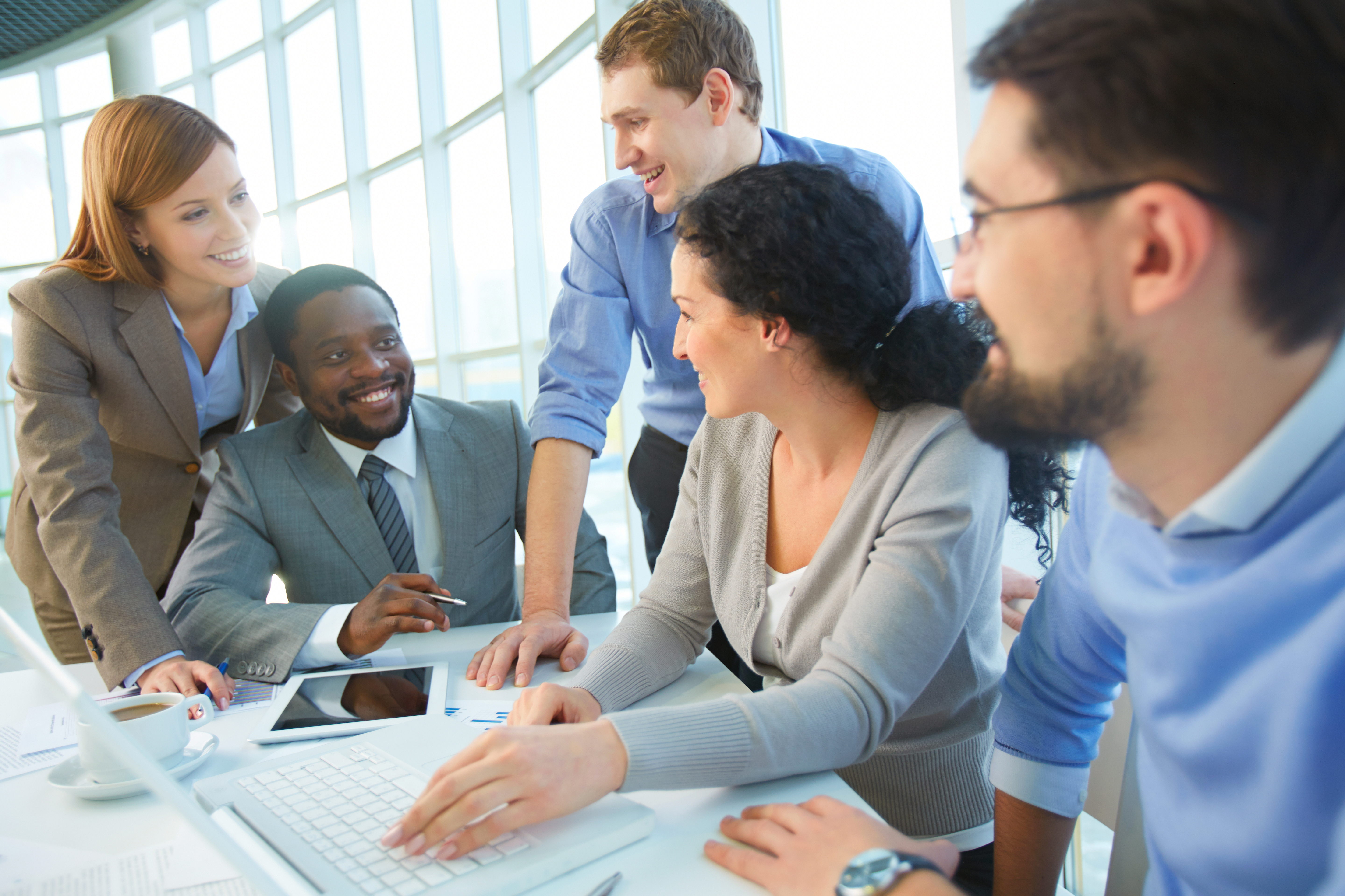 Group of cheerful business partners planning work at meeting