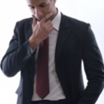 Portrait of a young business man looking depressed from work isolated over white background in studio